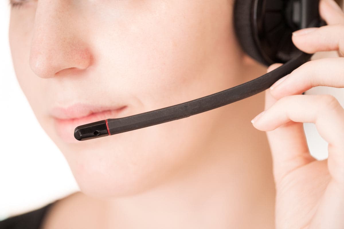 Customer service representative wearing a headset and assisting a customer.
