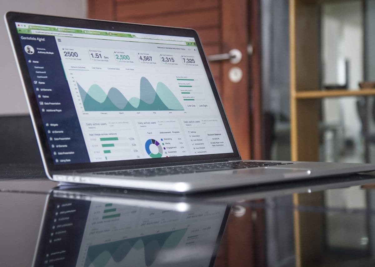 A digital web dashboard displaying ecommerce order logs, transaction data charts, and inventory statistics on a sleek monitor.